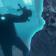 A person holds a cross in front of a zombie.